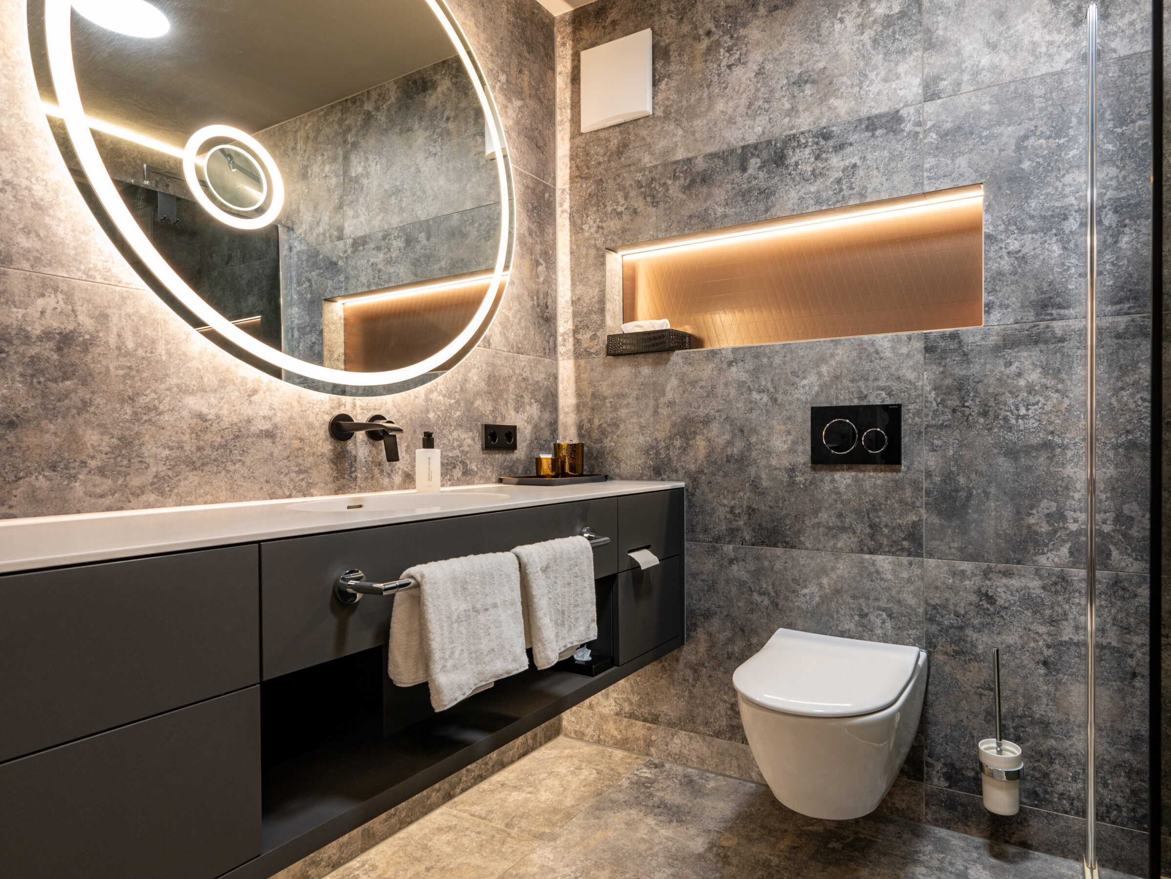 Badezimmer im Superior Zimmer mit Rundspiegel und modernem Design.
