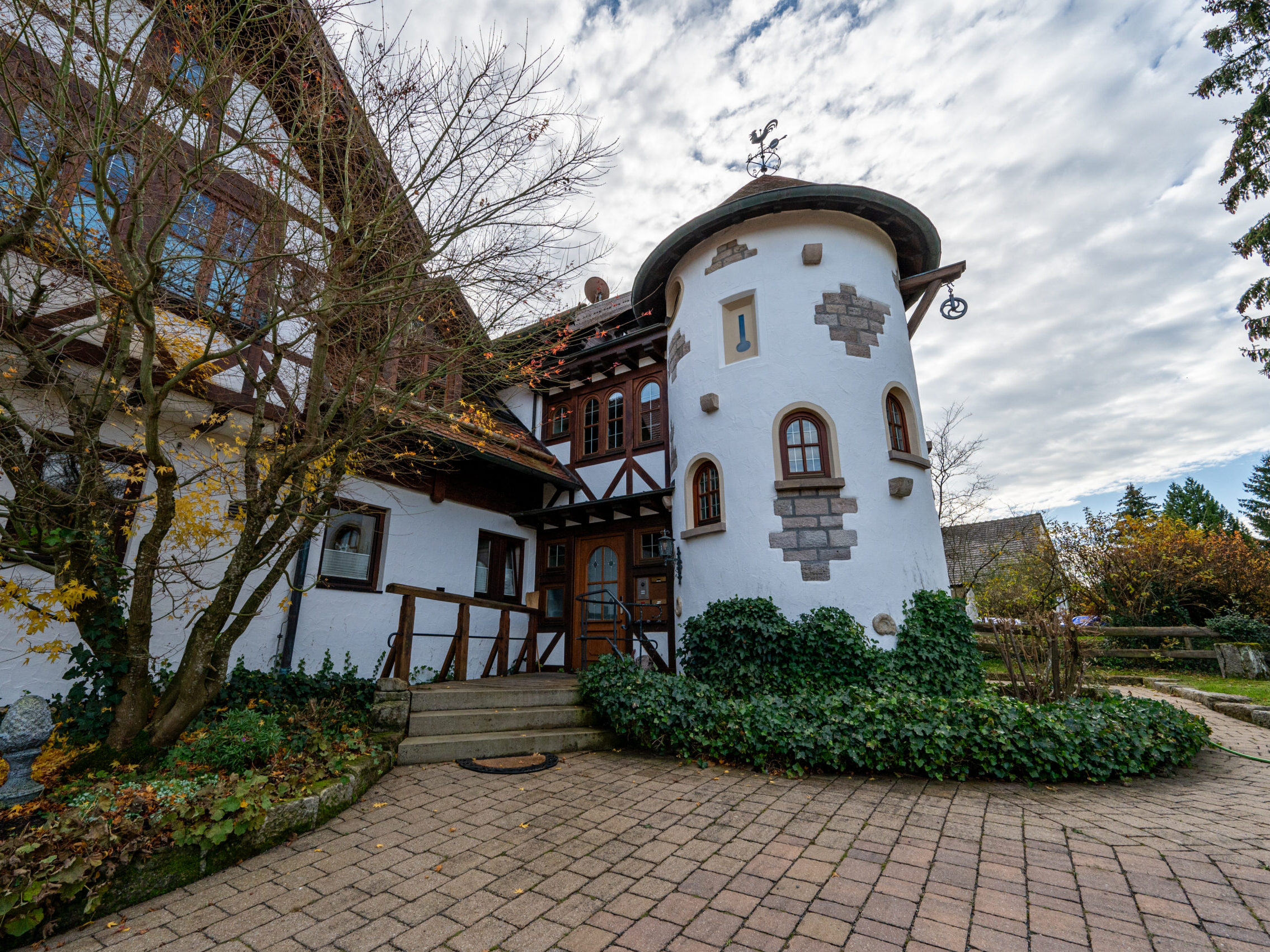 Charmantes Türmchen mit Chalet-Fassade und Efeubewuchs.