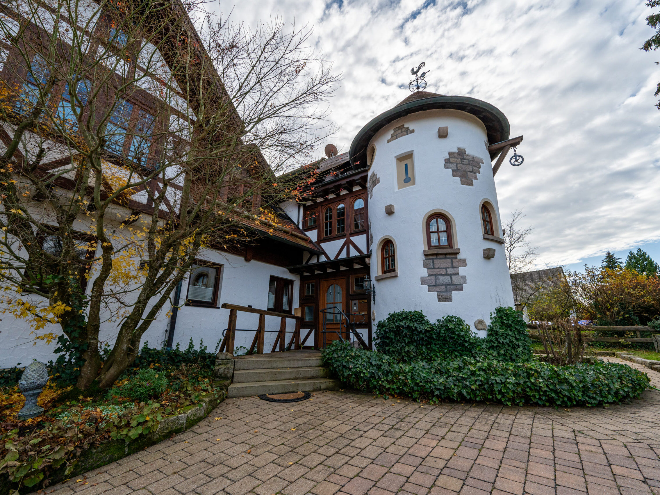 Charmantes Türmchen mit Chalet-Fassade und Efeubewuchs.