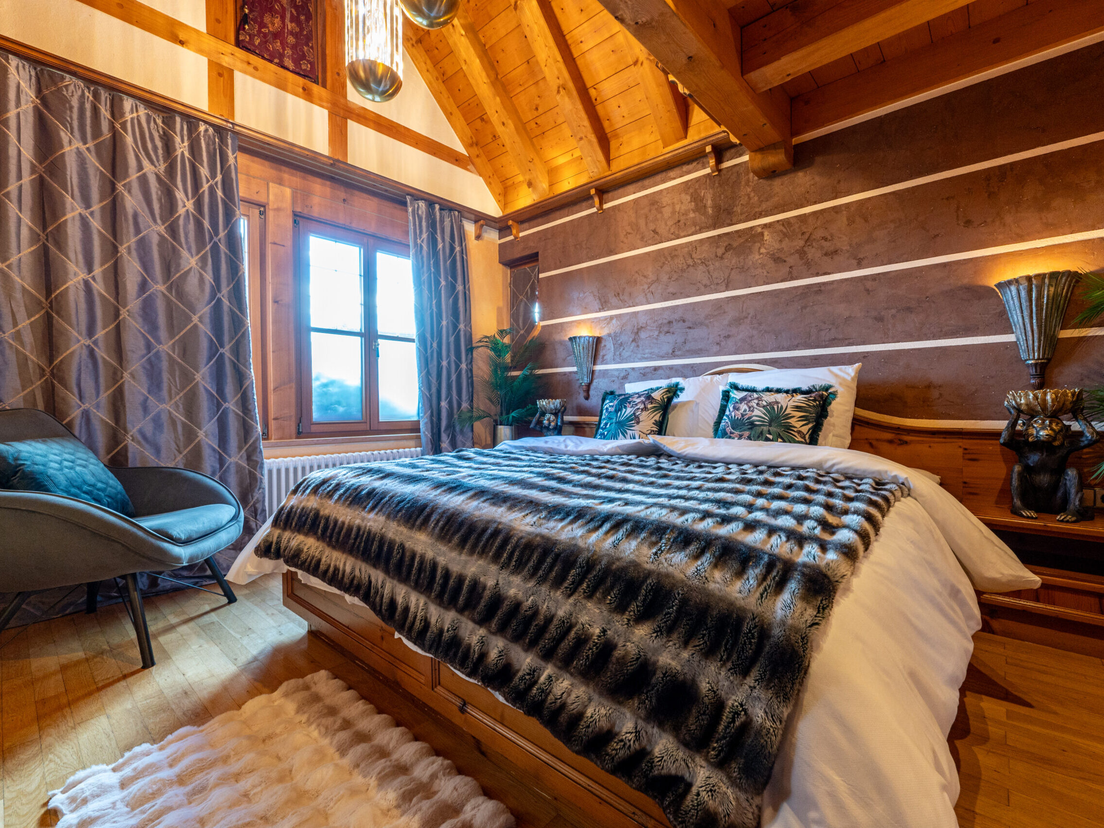 Gemütliches Schlafzimmer mit edler Bettwäsche, Holzelementen und Dekokissen.