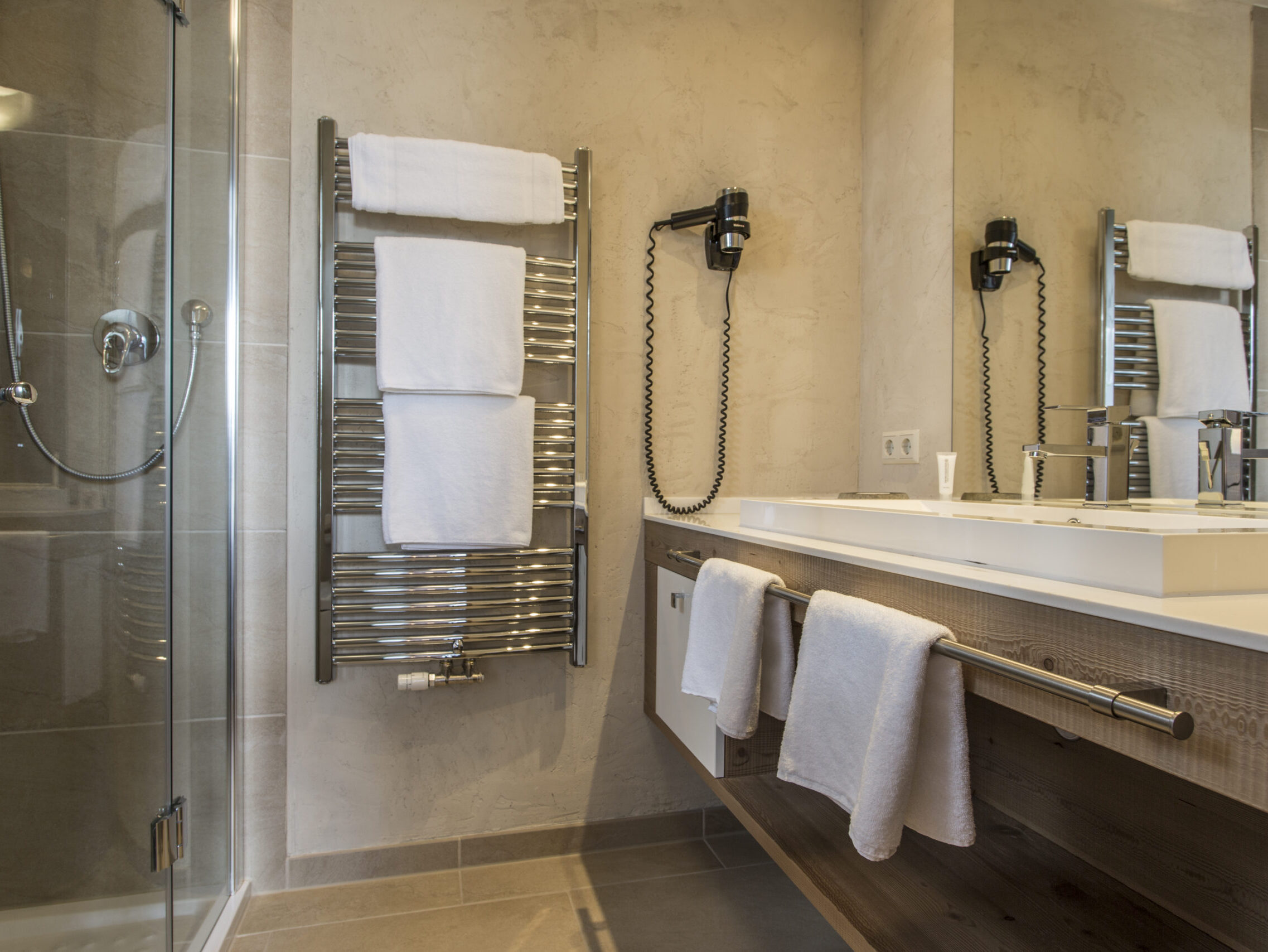 Ebenerdiges Badezimmer mit begehbarer Dusche, Handtuchwärmer und Doppelwaschbecken