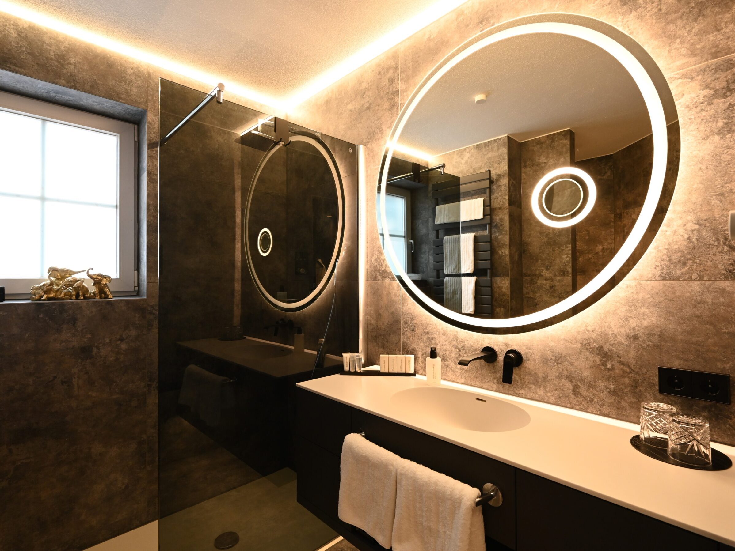 Modernes Badezimmer mit stimmungsvoller Beleuchtung und hochwertiger Ausstattung.