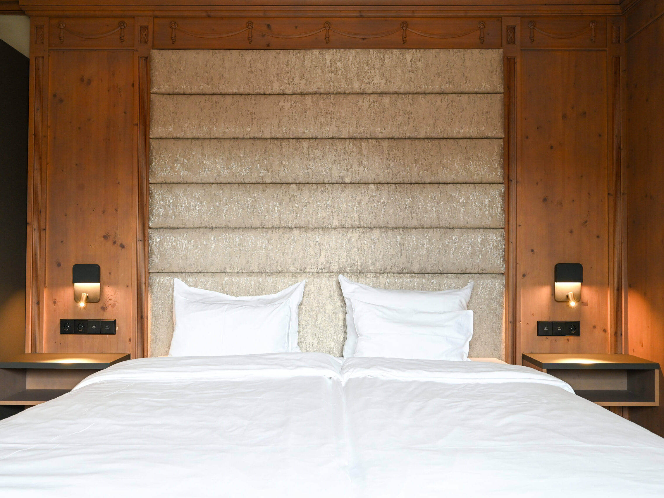 Kingsize-Bett mit edler Holzverkleidung, für stilvolle Nächte.