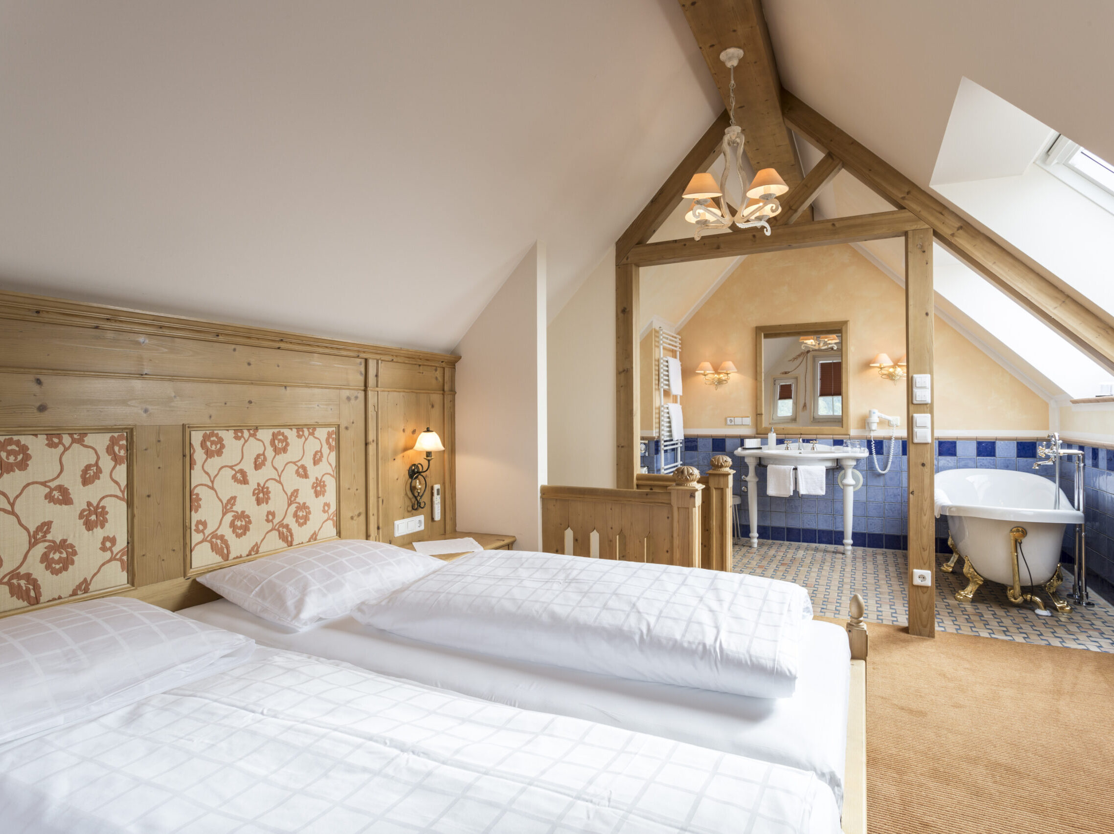 Schlafzimmer mit gemütlichen Doppelbett und kombinierten Badezimmer mit freistehender Badewanne.